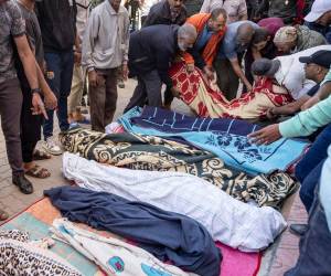 Los cuerpos son apilados poco a poco en el suelo.