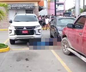 El cuerpo del hombre quedó tendido en el estacionamiento del centro comercial, luego de salir de una agencia bancaria.