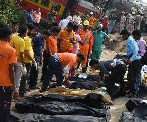 Vagones retorcidos se apilan unos encima de otros y líneas de cadáveres yacen junto a las vías en el este de India, donde los primeros rayos de sol muestran el horror de uno de los accidentes ferroviarios más mortíferos en la historia del país.