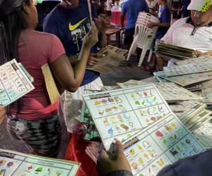 Personas seleccionan cartones de bingo en Ciudad Guayana, estado de Bolívar, Venezuela, el 5 de noviembre de 2022.
