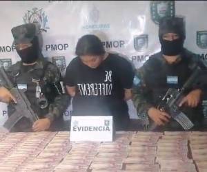 La mujer agachaba su cabeza para evitar ser vista cuando estaba siendo presentada por la Policía Militar.