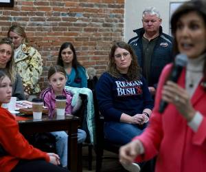 La gente escucha mientras la candidata presidencial republicana, ex embajadora ante la ONU, Nikki Haley, habla durante una parada de campaña en The Bread Board el 15 de enero de 2024 en Pella, Iowa. Los republicanos de Iowa se dirigen hoy a los caucus electorales y se convierten en los primeros en seleccionar al candidato de su partido para la carrera presidencial de 2024.