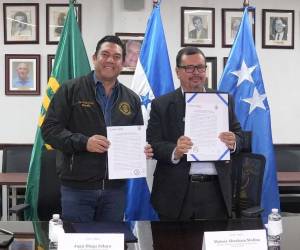 El alcalde del Distrito Central, Juan Diego Zelaya junto al titular de la Secretaría de Agricultura y Ganadería, Moisés Molina, sostienen el documento oficial que sella este convenio.