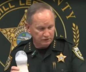 El sheriff Bill Leeper, sostiene en su mano un biberón mientras explica el horrendo caso.
