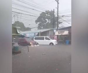 Los vehículos presentan problemas para transitar por las calles inundadas.