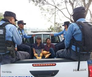 Dos de los detenidos cuando eran trasladados con sus manos cubiertas para proteger la evidencia que pudiera haber en sus manos tras el crimen múltiple.