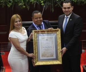 Momento en el que Alex Pérez recibió el reconomiento de Fotógrafo del Año 2026. En la foto posa junto al presidente del Congreso Nacional, Tomás Zambrano y una diputada.