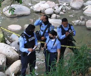 Agentes de la Dirección Policial de Investigaciones (DPI) en una escena del crimen en el Distrito Central.