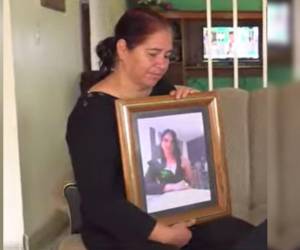 Suyapa Cantillano sostiene en su manos un cuadro con la fotografía de su hija muerta.