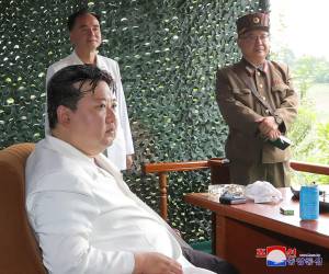 Kim Jong Un luce distraído mientras al fondo se observa el teléfono celular.