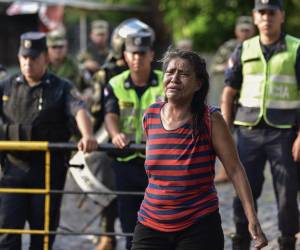 Familiar de un preso protesta cuando la policía transportaba a detenidos de la cárcel de Tacumbú en Asunción hacia otros centros penales, este lunes 18 de diciembre de 2023.