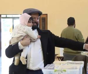 El mandatario llegó acompañado de su padre y cargando en brazos a su hija recién nacida, Violeta, mientras saludaba a los ciudadanos que esperaban en fila bajo un clima soleado.