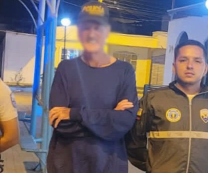 La fotografía muestra al exdiplomático cruzado de brazos, con una gorra de la policía y erguido entre dos uniformados.