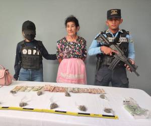 La droga la escondía en la cartera rosada, al igual que el dinero de la venta.