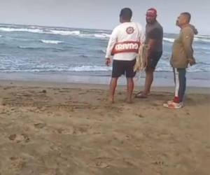 Rescatistas observan el mar alterado debido al ingreso del frente frío en Veracruz.