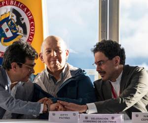 Miembros de las delegaciones del gobierno colombiano se daban la mano en señal de buenas noticias respecto a acuerdo de paz.