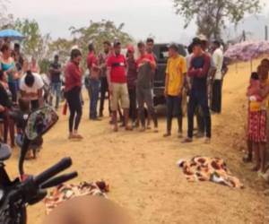 Lugareños observan los cuerpos de la madre y su hijo tirados en el suelo y cubiertos con mantas.