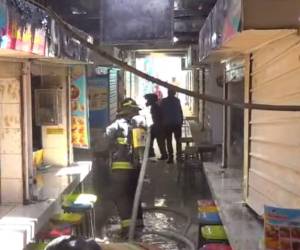 Varios vendedores fueron desalojados de sus puestos mientras los bomberos realizaban labores para controlar el fuego.