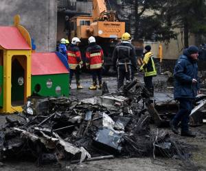 Los bomberos trabajan cerca del lugar donde un helicóptero se estrelló cerca de un jardín de infantes en Brovary, en las afueras de la capital, Kyiv, y mató a catorce personas.