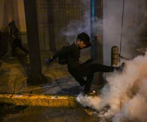 Un partidario del expresidente peruano Pedro Castillo patea un bote de gas lacrimógeno a la policía antidisturbios durante una protesta cerca del Congreso en Lima el 12 de diciembre de 2022.