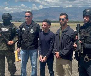 Momento en que el hondureño era custodiado antes de abordar el avión para llevarlo a Estados Unidos.