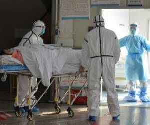 Trabajadores médicos con trajes protectores trasladan a un paciente con coronavirus a una sala de aislamiento en el Segundo Hospital del Pueblo en Fuyang, en la provincia central china de Anhui, el sábado 1 de febrero de 2020. Beijing criticó el endurecimiento de los controles de viaje de Washington para prohibir a la mayoría de los extranjeros que visitaron el país en las últimas dos semanas (Chinatopix a través de AP)