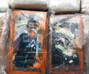 Esta foto provista por el Ministerio del Interior de Perú muestra paquetes de cocaína con fotos del narcotraficante Joaquín 'El Chapo' Guzmán, izquierda, y el fallecido Pablo Escobar, derecha, durante una incautación en Chancay, Perú, el miércoles 30 de mayo de 2018.