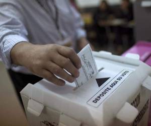 Un elector deposita su voto en los pasados comicios de 2013, que ganó JOH.