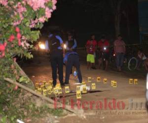 Elementos policiales realizan pesquisas en la escena donde se perpetró la masacre que dejó siete muertos la noche del jueves en la colonia 9 de Diciembre de Puerto Cortés. FOTOS: EL HERALDO