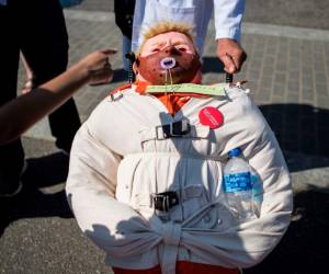 Un niño apunta a una muñeca, representando al presidente estadounidense Donald Trump, cerca de la Casa Blanca antes del inicio de la Marcha por la Ciencia en Washington. Foto Agencia AFP.