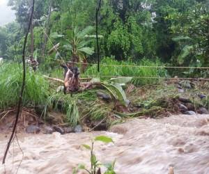 Auxiliados con dos cuerdas el bombero traslada de uno en uno a las personas atrapadas al otro lado del río. (Foto cortesía: Bomberos/ El Heraldo Honduras, Noticias de Honduras)