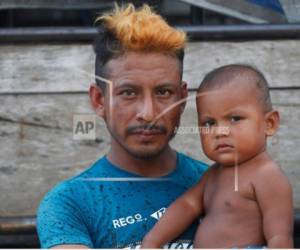 Luis Martínez, de 29 años, y su hijo Fernando Alonso, de 1 año, posan para una foto después de llegar a Mapastepec, México, el miércoles 24 de octubre de 2018. Martínez, albañil de Santa Ana en el oeste de El Salvador. Viaja con su esposa y sus tres hijos. 'Con los 5 dólares que gano por día, ni siquiera puedo alimentar a mis hijos, así que decidí unirme a la caravana', dijo.