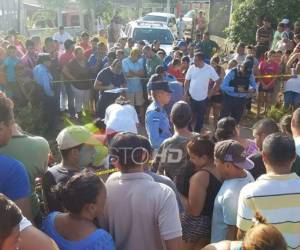 Las víctimas quedaron a la par de una motocicleta. Cientos de vecinos acudieron a la escena del crimen.