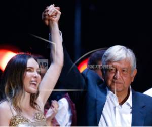 En esta fotografía del 27 de junio de 2018 se muestra al candidato presidencial Andrés Manuel López Obrador y a la cantante Belinda durante el cierre de campaña del candidato en el Estadio Azteca, en la Ciudad de México.