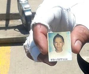 El padre de Gerson Misael Galindo muestra su foto, mientras espera que le entreguen su cadáver en el Hospital Escuela.