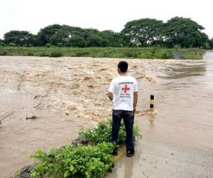 Un voluntario de la Cruz Roja Hondureña observa la crecida del río Goascorán.