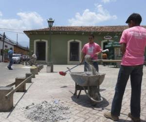 Jóvenes de la Escuela Taller realizan los trabajos de reparación de adoquines de la plaza central.