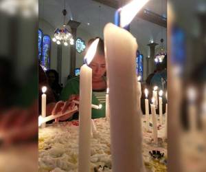 Con velas y oraciones, una devota saluda a la Virgen.