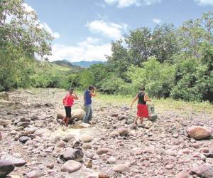 Las mujeres de Texíguat acarrean el agua para sus quehaceres desde el río Texíguat, que en la actualidad se ha quedado sin caudal.
