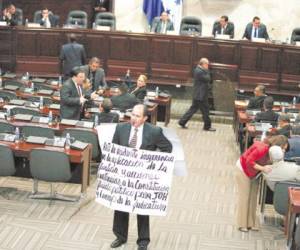 Este diputado de Libre, José Luis Cruz, se paseó por el hemiciclo con un cartel escrito con errores ortográficos y con pito en boca.