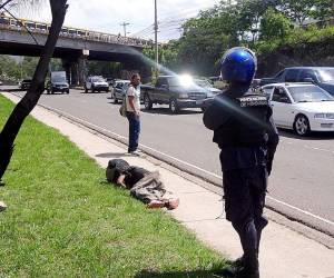 El cuerpo sin vida del presunto asaltante quedó tendido a un costado del anillo periférico de la capital de Honduras. (Fotos: Estalin Irías)