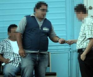 1. El pago. El empleado de la clínica (izquierda) recibe del reportero de EL HERALDO el pago de 1,200 lempiras para tramitar una licencia sin hacer el examen de conducir.