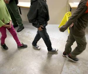 This US Customs and Border Protection photo released on March 23, 2021 shows migrants in the temporary processing facilities in Donna, Texas, as they safely processes family units and unaccompanied alien children (UACs) encountered and in the custody of the US Border Patrol on March 17, 2021. - The facility will bolster processing capacity in the RGV while the permanent Centralized Processing Center in McAllen, Texas is renovated. (Photo by Jaime RODRIGUEZ Sr. / US Customs and Border Protection / AFP) / RESTRICTED TO EDITORIAL USE - MANDATORY CREDIT 'AFP PHOTO /US CUSTOMS AND BORDER PROTECTION/JAIME RODRIGUEZ,SR./HANDOUT ' - NO MARKETING - NO ADVERTISING CAMPAIGNS - DISTRIBUTED AS A SERVICE TO CLIENTS