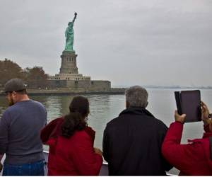 FILE - In this Nov. 5, 2015, file photo, visitors view the Statue of Liberty during a ferry ride to Liberty Island in New York. The travel industry is debating whether President Donald Trump's ban on travel from seven countries will have a larger impact on tourism in the U.S. Some experts say the controversy will have no effect while others worry that it sends an unwelcoming message to travelers around the world. An op-ed piece in the Toronto Star on Jan. 30, 2017, encouraged Canadians to boycott the U.S. for now, saying that the Statue of Liberty will still be there in a few years. (AP Photo/Bebeto Matthews, File)