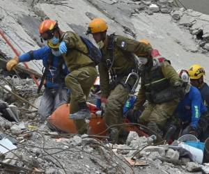 Los rescatistas eliminan el cuerpo de un hombre que sobrevivió al terremoto pero murieron antes de que pudieran llegar a él durante la búsqueda de sobrevivientes en un edificio aplanado en la Ciudad de México. / AFP / YURI CORTEZ