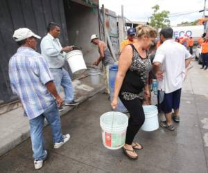 Con un balde en cada mano, una dama llevó el líquido hasta su vivienda. Foto: Johny Magallanes/EL HERALDO.