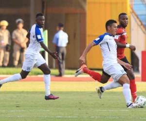 Roger Espinoza conduce a el balón ante la mirada del trinitense (Foto: EL HERALDO)