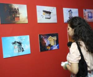 Una joven observa las ilustraciones en la exposición que se realizó en Mua.