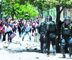 Un reducido grupo de policías municipales repelía el ataque de los vendedores. Es el segundo día de fuertes enfrentamientos. Foto: Alejandro Amador/EL HERALDO.