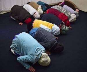 La humilde mezquita de la comunidad islámica Ahmadía, improvisada en una casa con techos de lámina, contrasta con la que se erige en la acera de enfrente, perteneciente a los Murabitún y que cuenta con una gran cúpula y un alminar.